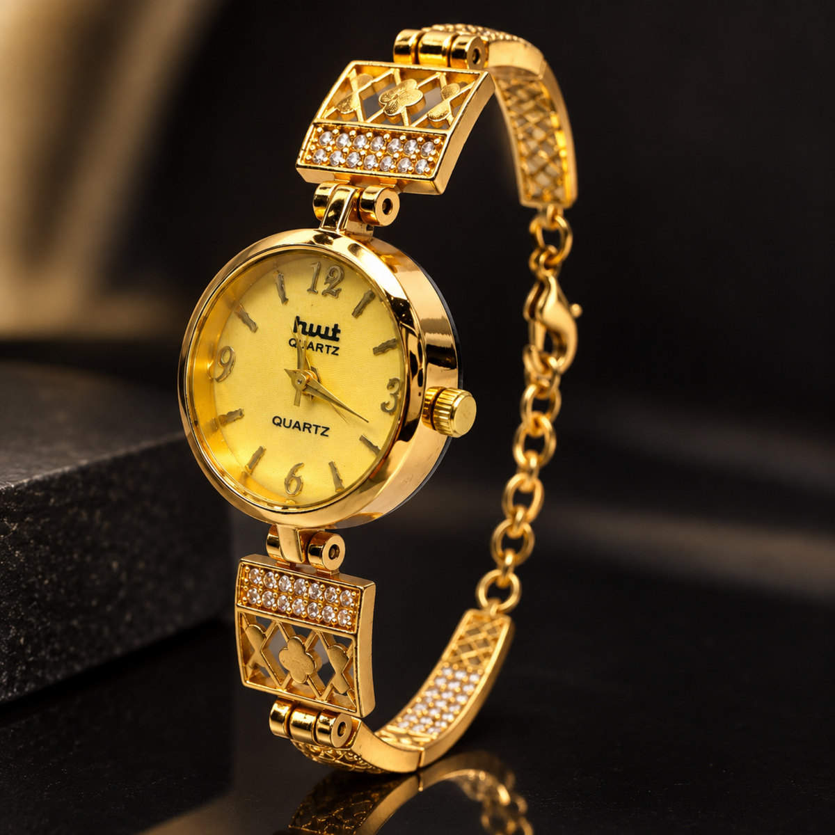 Close up of gold crystal clover lattice bracelet watch with mesh chain
