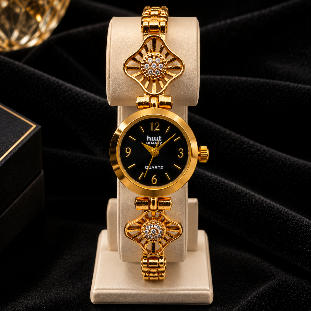 Gold plated starburst crystal bracelet watch on display stand