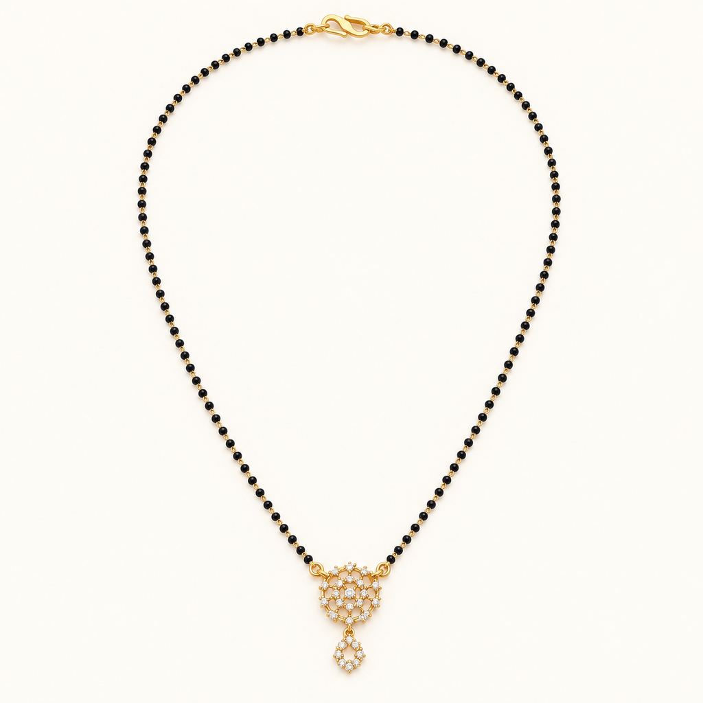 Gold-tone black bead mangalsutra with a sparkling floral cluster pendant and small dangling charm on a white background.