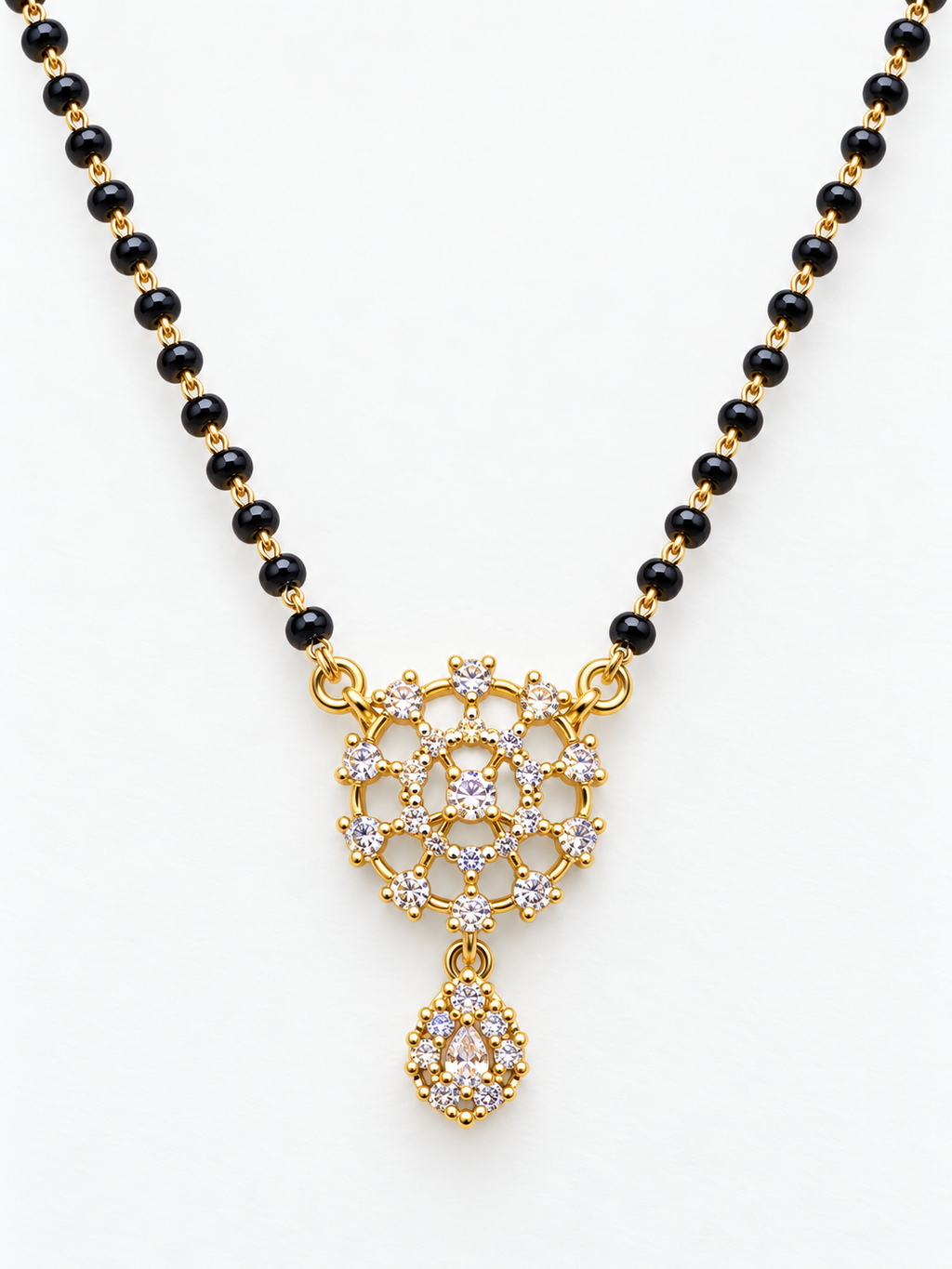 A gold and black beaded necklace with a detailed gold pendant set with clear stones, displayed on a clean white background.