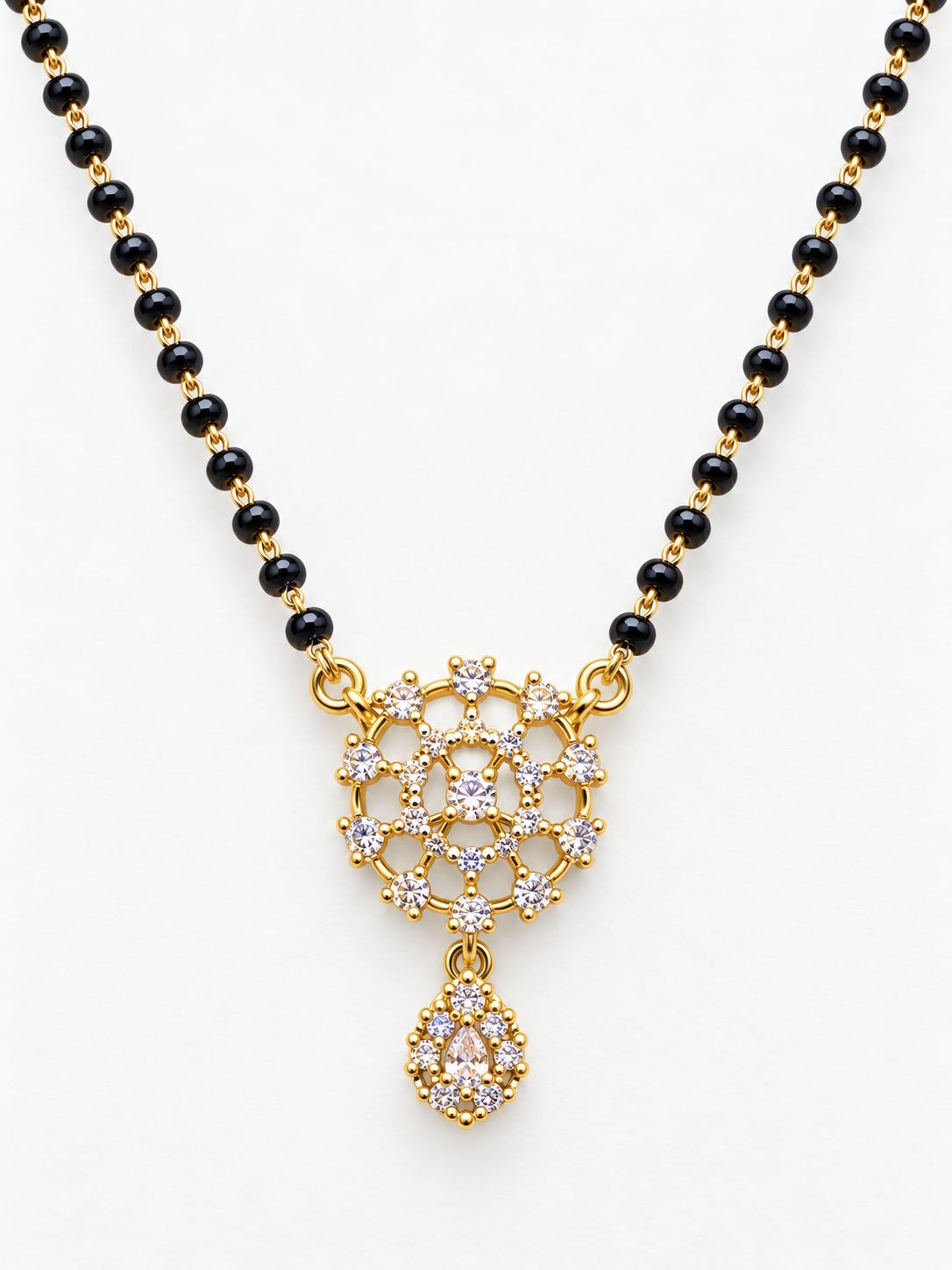 A gold and black beaded necklace with a detailed gold pendant set with clear stones, displayed on a clean white background.