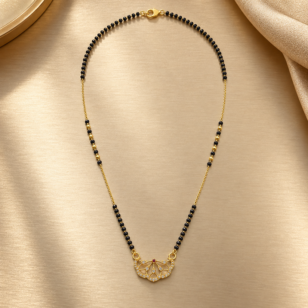 A gold and black beaded necklace with a butterfly-shaped pendant, displayed on a textured beige satin fabric.