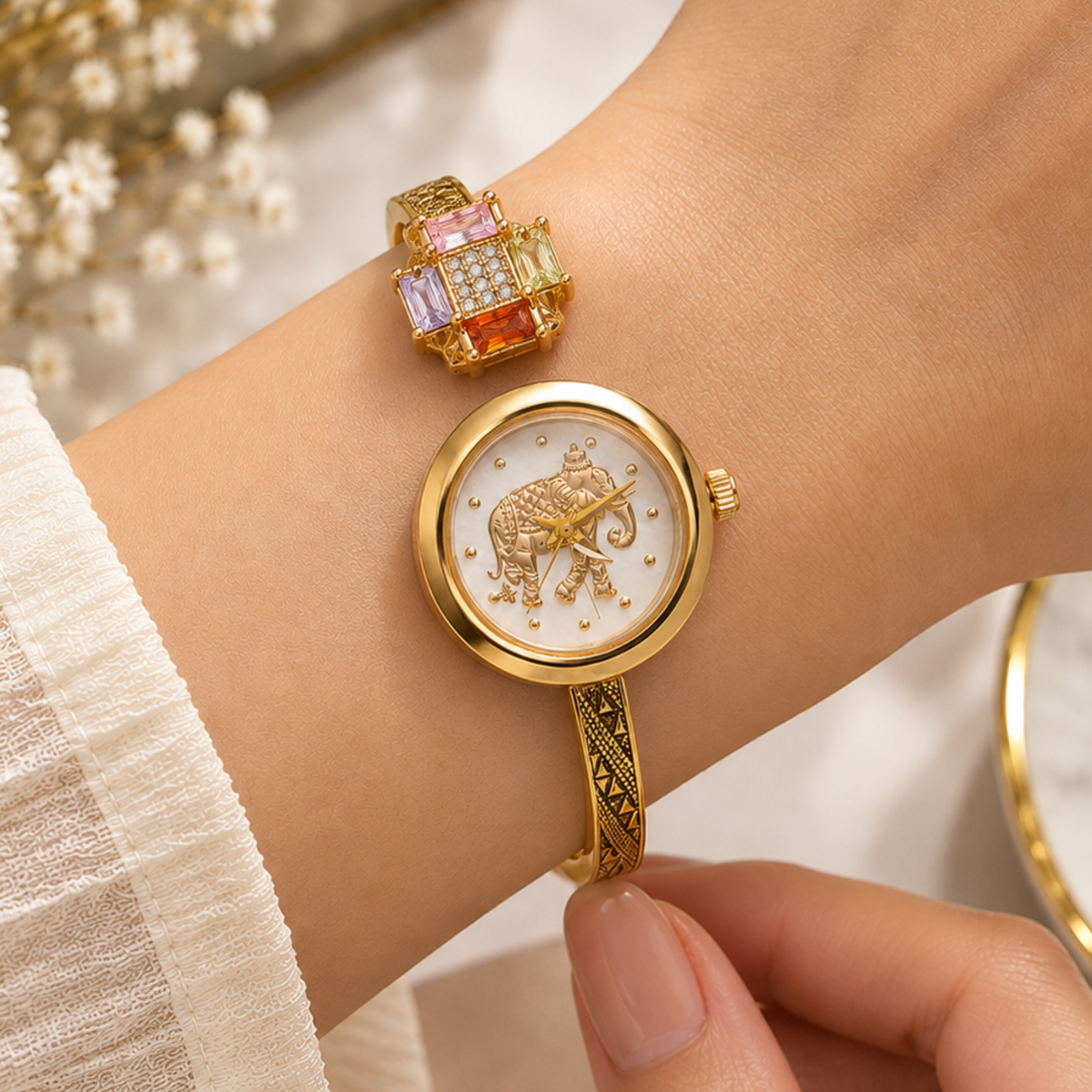 Woman wearing gold elephant dial gemstone cuff watch
